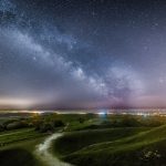 The milkyway shines in the distance from on top of Cissbury Ring in Worthing