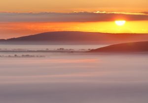 A beautiful golden sunrise above a misty valley