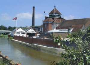 A brewery in the middle of a town with a large chimney