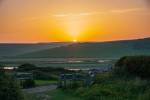 The sun rising of the Cuckmere valley with a bright orange sky