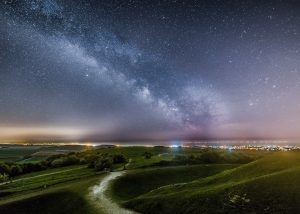 The milkyway shines in the distance from on top of Cissbury Ring in Worthing