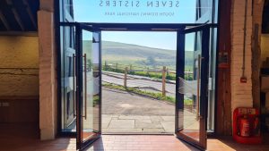 The newly refurbished visitor centre at Seven Sisters looking out towards the A272 road and the green hills of the South Downs