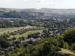 Rolling green hills with a town and homes