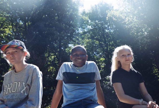 Three teenagers sitting in a forest