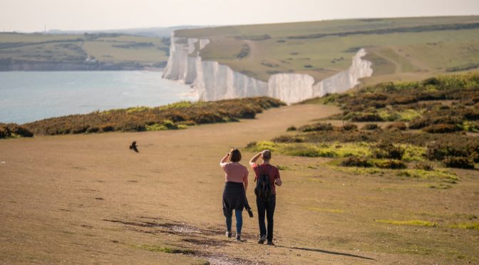 Two people staring at the white cliffs at Seven Sisters